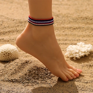 Detail bunter Perlen-Fußkettchen, am Sandstrand bei natürlichem Außenlicht getragen