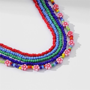 Detail of colorful African waist beads set with elastic glass seed beads and floral charms