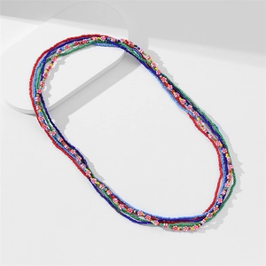 Macro shot of colorful beaded waist chains with small floral accents on white background