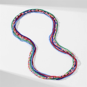 Detailed view of colorful multi-layered African glass beads with small pink floral accents