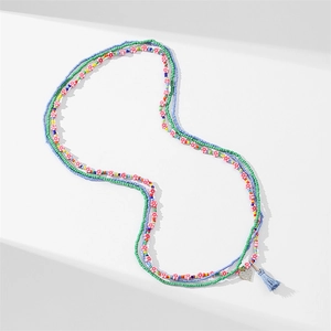 Detail of colorful African waist beads featuring crystal heart pendant and blue tassel
