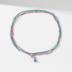 Detail of colorful African waist beads with heart pendant and soft blue cotton tassel