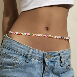 Detail of colorful African waist beads styled with high-waisted denim for beach fashion