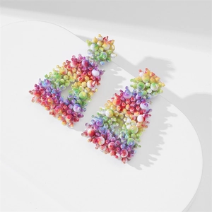 Detailed view of colorful handmade bead earrings with 3D bubble texture on a white stand