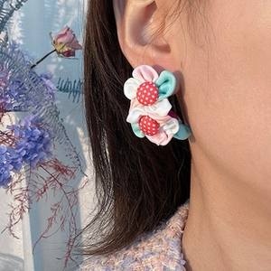 Vue détaillée de boucles d'oreilles fleurs en tissu faites main avec bouton à pois