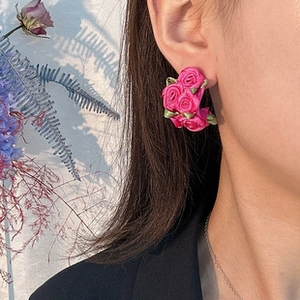 Détail de boucles d'oreilles roses en tissu sur modèle, bijoux floraux coréens