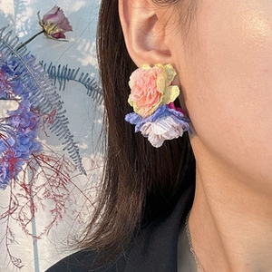 Gros plan de boucles d'oreilles fleurs en tissu élégantes portées par un mannequin