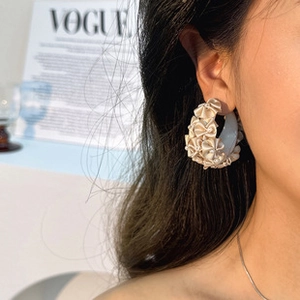 Détail de la boucle d'oreille créole en acrylique avec plis de satin et perles