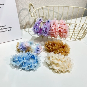 Détail de chouchous floraux en tissu coloré avec perles fantaisie centrées en lot