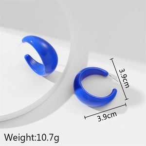 Klein blue acrylic C-shaped earrings with 3.9cm size on a minimalist mirror display