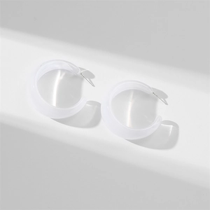 Macro detail of white translucent resin C-shaped hoop earrings with silver metal posts
