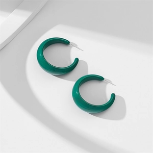 Detailed view of dark green acrylic C-shaped earrings with smooth resin finish