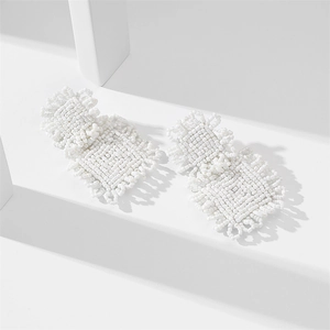 Handmade white seed bead square earrings on minimalist geometric background