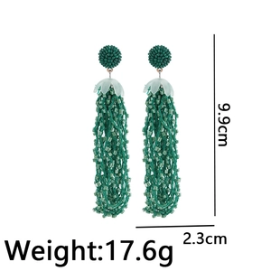 Detail view of 9.9cm long green beaded tassel earrings with bohemian floral accents