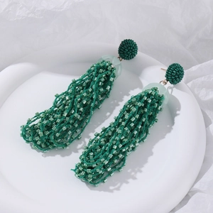 Detail of green bead tassel earrings showing handcrafted beaded texture and layered fringe