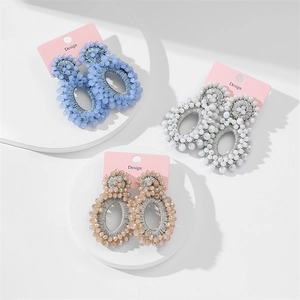 Detailed view of handmade beaded oval earrings in sky blue, white and champagne colors