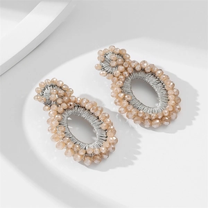 Detail of handmade champagne beaded earrings with intricate silver thread weaving