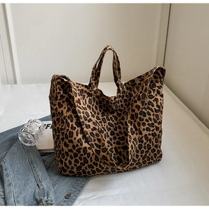 Detail of a large leopard print canvas tote bag on a white bed for stylish daily commute