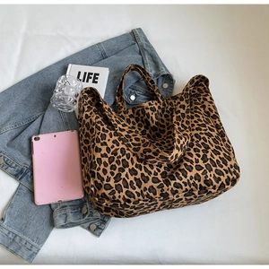 Flat lay of leopard print canvas tote bag with fashion accessories and lifestyle props