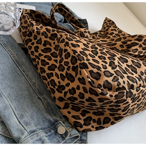 Detailed close-up of leopard print canvas tote bag featuring high-density twill fabric texture