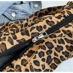 Close-up of leopard print canvas tote bag with silver zipper and reinforced stitching