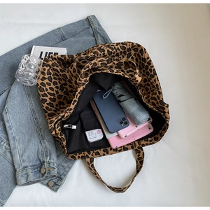 Interior view of leopard print tote bag showing large capacity with pockets and gadgets