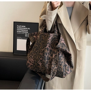 Detail of leopard print tote bag with wide shoulder strap worn with trench coat