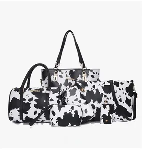 Detailed view of 6-piece women's handbag set featuring high-contrast cow print and gold hardware