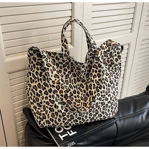Detail shot of canvas tote bag featuring classic leopard print on a black fashion book