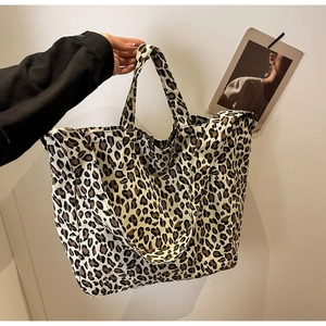 Detail of leopard print canvas tote bag featuring double handles and spacious design