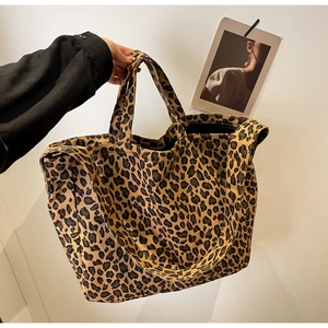Detail view of the leopard print canvas tote bag with sturdy handles and shoulder strap