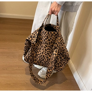 Detail showing high-capacity leopard print tote bag with brown straps and canvas texture