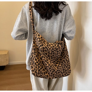 Close-up of leopard print tote bag on shoulder against a minimalist interior background
