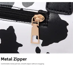 Detailed close-up of smooth gold zipper and leopard cow print faux leather material