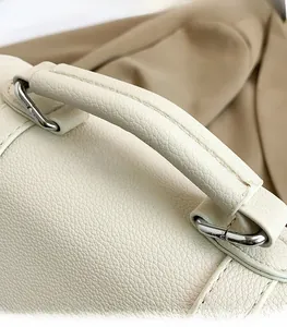 Close-up of litchi textured faux leather handbag handle with silver hardware