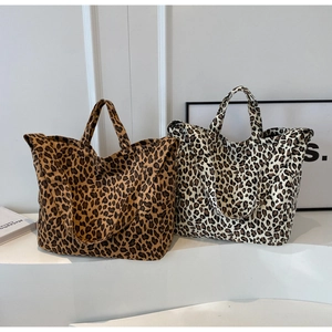 Detail of leopard print canvas tote bags in brown and white with durable top handles
