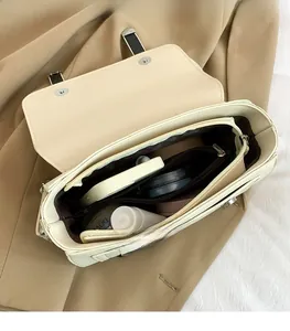 Interior view of beige shoulder bag showing large capacity with phone and cosmetics