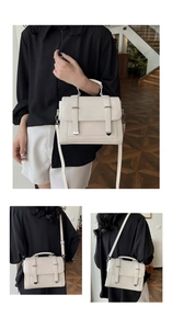 Detail view of cream white litchi pattern leather satchel with silver hardware and strap