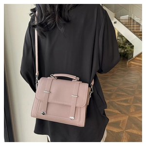 Detail view of pink vintage crossbody bag with lychee texture and silver buckles