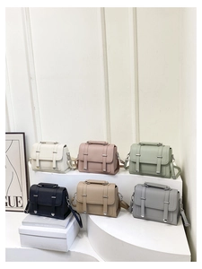 Selection of minimalist PU leather satchels in six colors on a white display stand