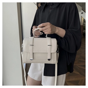 Close-up of cream white lychee texture handbag with silver buckles on a female model