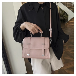 Detailed close-up of pink lychee grain faux leather handbag with silver hardware clasp