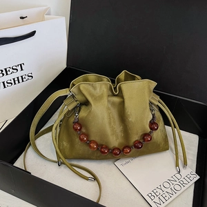 Olive green drawstring cloud bag with amber beaded chain in a minimalist gift box