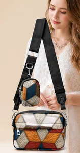 Detail of color-block crossbody bag with geometric patchwork and small round coin purse