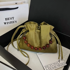 Olive green velvet bucket bag with amber beaded handle and drawstring in a gift box