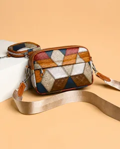 Detail of color-block crossbody bag with crocodile texture and detachable mini round purse
