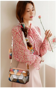 Detail of color-block geometric crossbody bag with matching round coin purse charm
