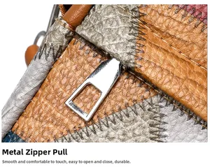 Detailed macro of smooth silver zipper hardware on a color-block pebbled leather bag