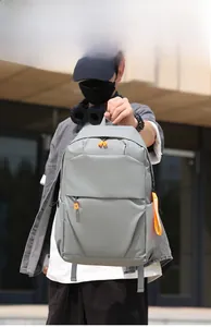 Detail of gray waterproof backpack featuring vibrant orange zippers and handle accents