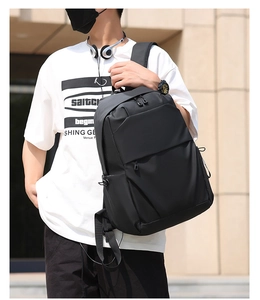 Outdoor shot of minimalist black backpack with geometric front pocket and padded straps